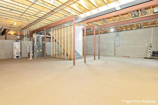 basement with heating unit, electric panel, and water heater