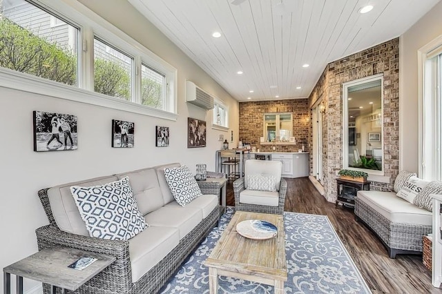 living room featuring brick wall, dark wood-type flooring, a wall mounted air conditioner, and wooden ceiling