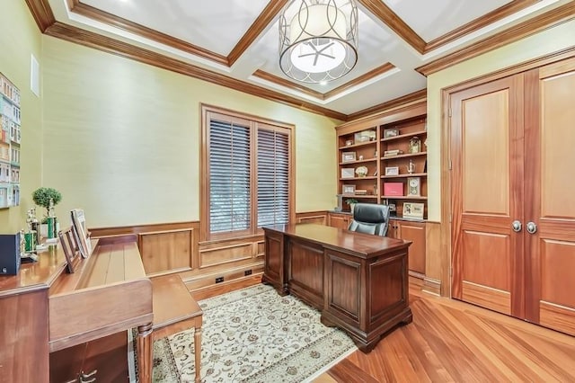 office space featuring built in shelves, ornamental molding, and light hardwood / wood-style flooring