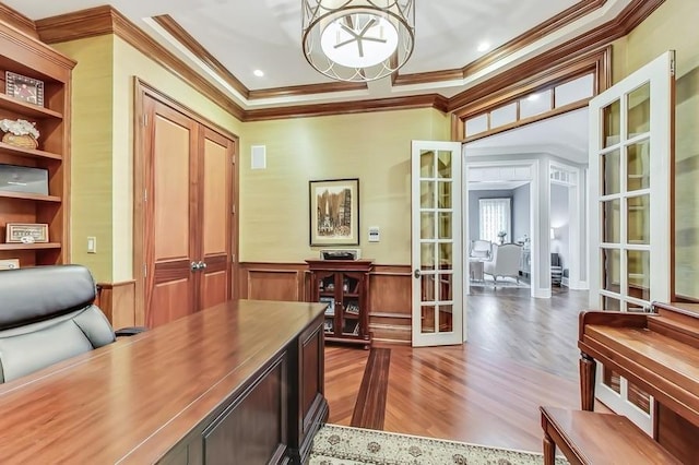 home office with french doors, crown molding, and hardwood / wood-style flooring