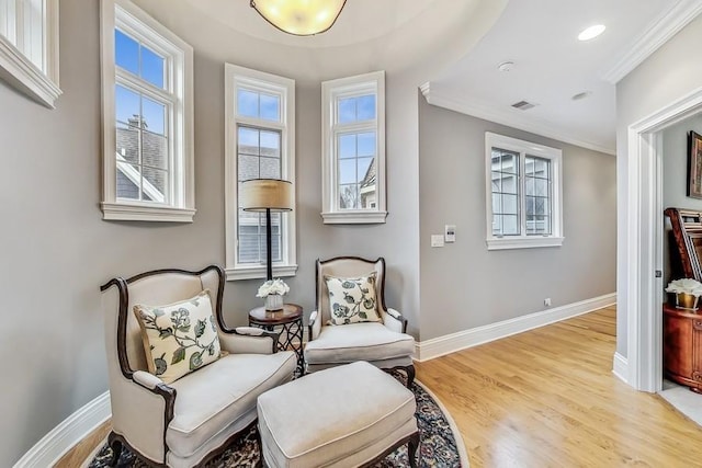 sitting room with ornamental molding, a healthy amount of sunlight, and light hardwood / wood-style floors