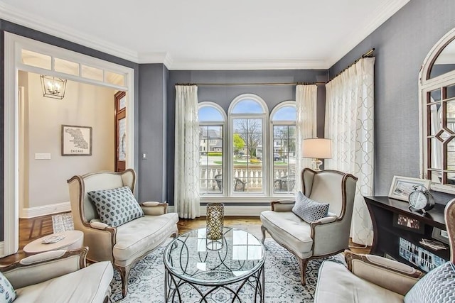 living area with a notable chandelier, crown molding, and hardwood / wood-style floors