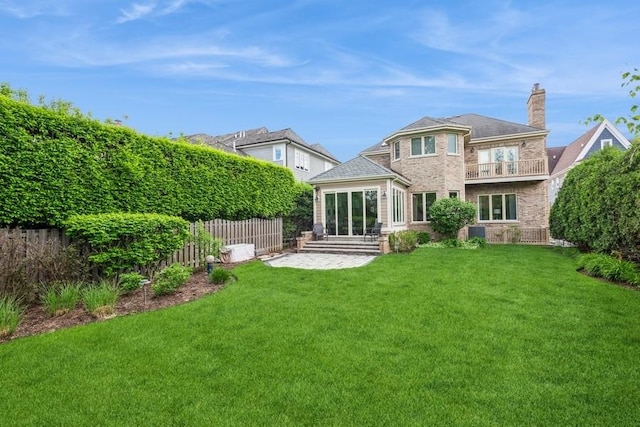 back of property featuring a balcony and a yard