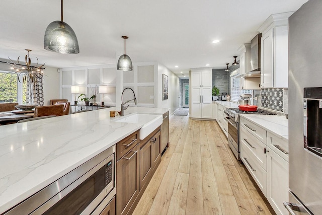 kitchen featuring stainless steel appliances, pendant lighting, and white cabinets