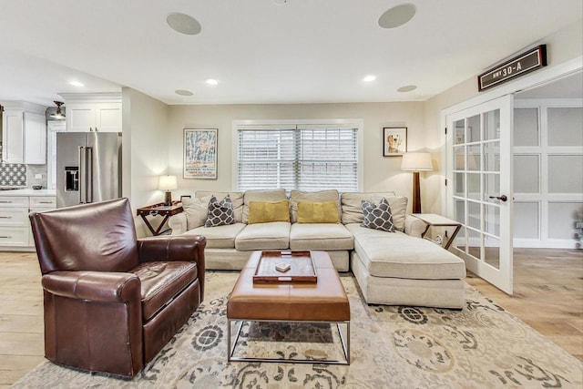 living room with french doors and light wood-type flooring