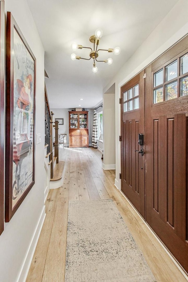 entryway featuring light hardwood / wood-style flooring and a notable chandelier