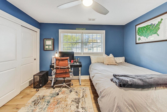 bedroom with light hardwood / wood-style floors, a closet, and ceiling fan