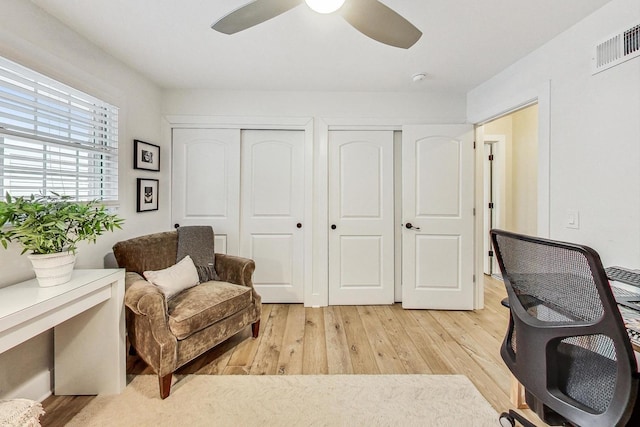 office with light hardwood / wood-style flooring and ceiling fan