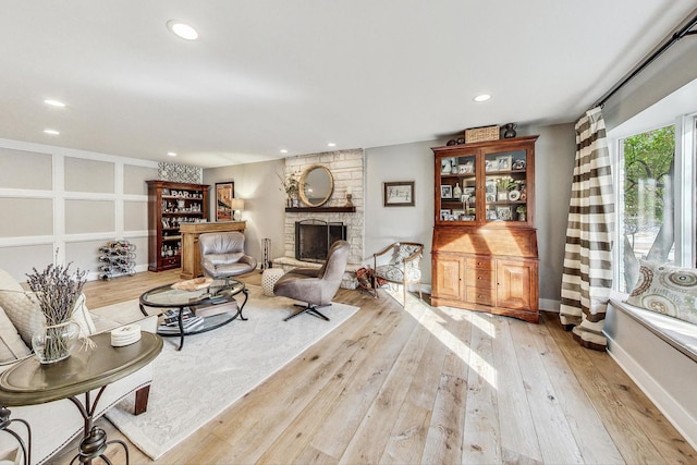 living room with a fireplace and light wood-type flooring