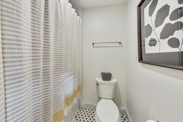 bathroom with toilet and a shower with shower curtain