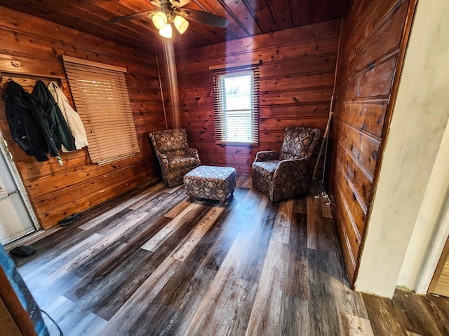 unfurnished room featuring ceiling fan, dark wood-type flooring, wood ceiling, and wooden walls