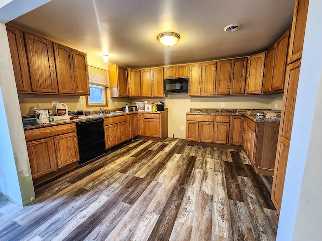 kitchen with dark wood-type flooring, sink, and black appliances