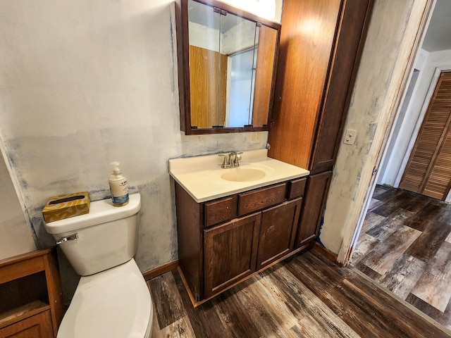 bathroom with wood-type flooring, vanity, and toilet