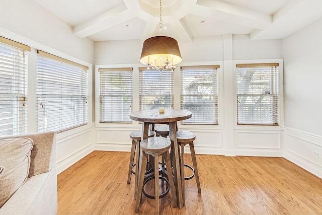 dining room featuring coffered ceiling, a wealth of natural light, a chandelier, and light wood-type flooring