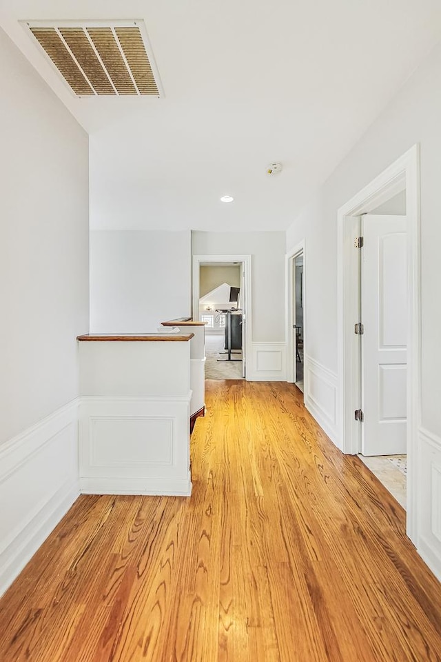 corridor with light hardwood / wood-style floors