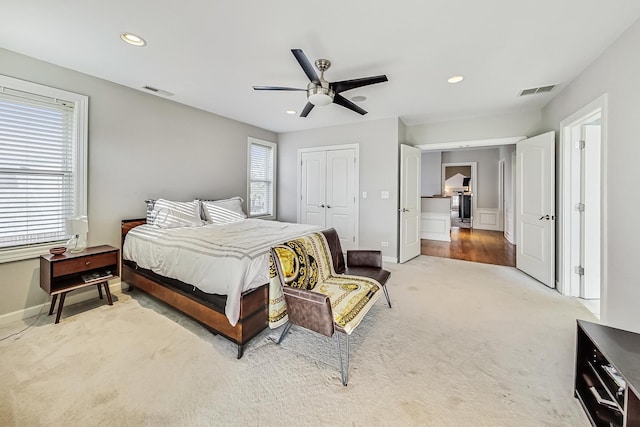 carpeted bedroom with multiple windows, ceiling fan, and a closet