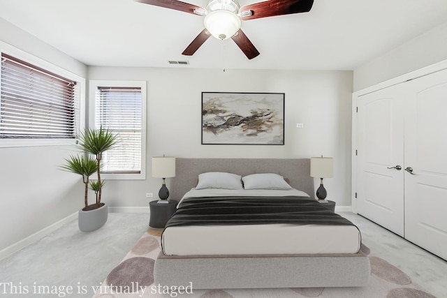 bedroom featuring ceiling fan, light colored carpet, and a closet