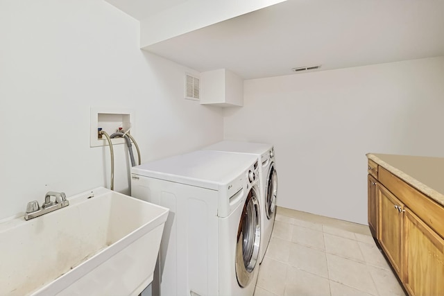 laundry area with separate washer and dryer, sink, cabinets, and light tile patterned flooring