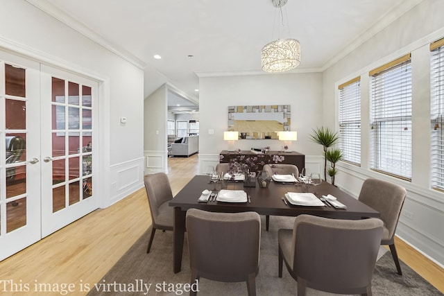 dining area featuring french doors, crown molding, and a notable chandelier