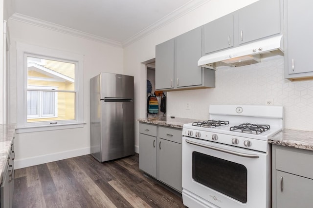 kitchen with white gas stove, under cabinet range hood, gray cabinets, and freestanding refrigerator