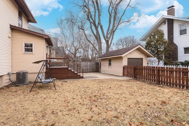 view of yard with a fenced backyard, cooling unit, a garage, an outdoor structure, and a patio area