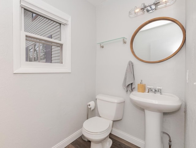 bathroom with a sink, wood finished floors, toilet, and baseboards