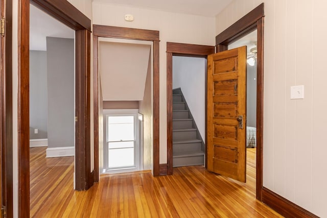 interior space featuring light wood-type flooring, baseboards, and stairs