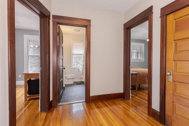 hall featuring light wood finished floors and baseboards