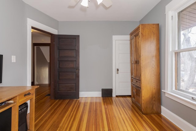 unfurnished bedroom with visible vents, light wood-style flooring, and baseboards