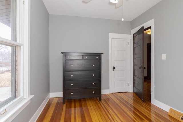 unfurnished bedroom featuring visible vents, baseboards, and wood finished floors