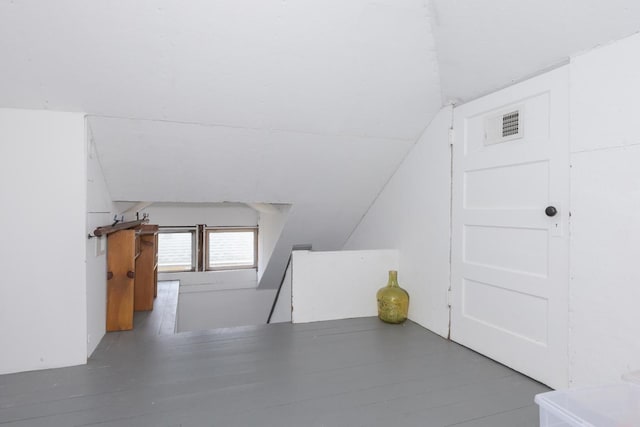 bonus room with lofted ceiling and wood finished floors