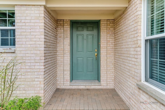 property entrance featuring brick siding
