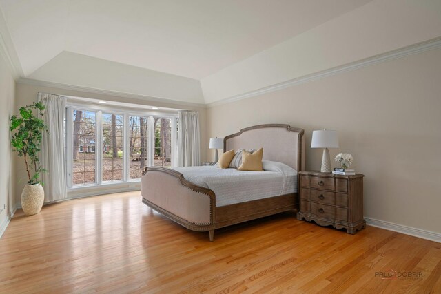 bedroom with lofted ceiling, baseboards, light wood-style floors, and crown molding