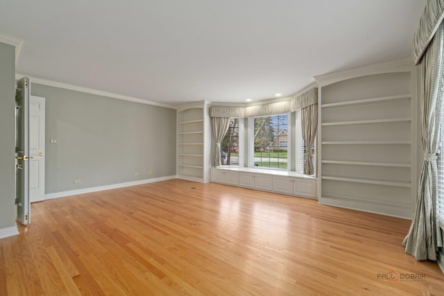 unfurnished living room featuring light wood-style flooring, crown molding, and baseboards