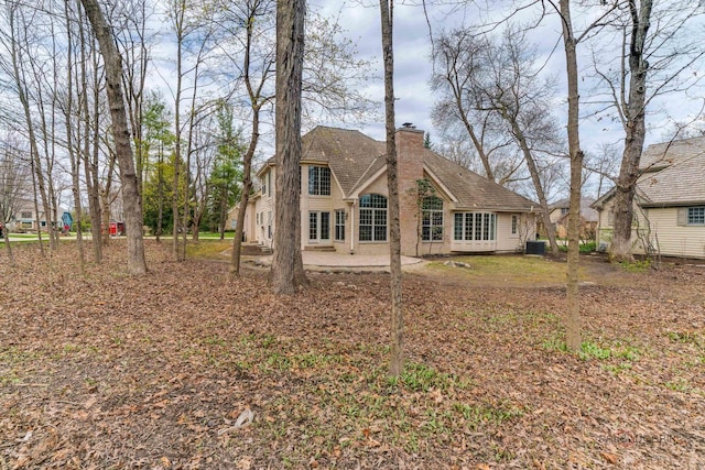 back of property featuring a chimney and a patio