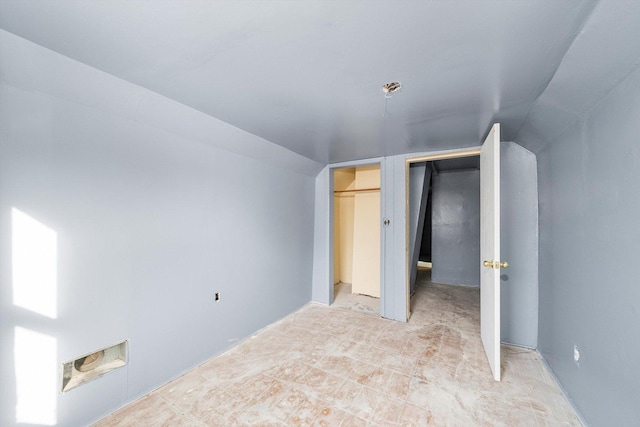 unfurnished bedroom featuring lofted ceiling