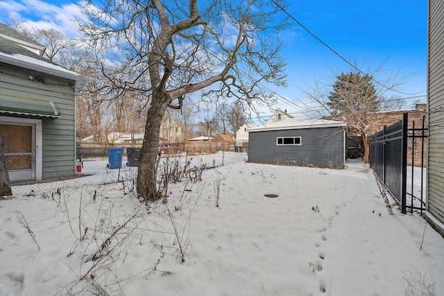 yard covered in snow with a storage shed