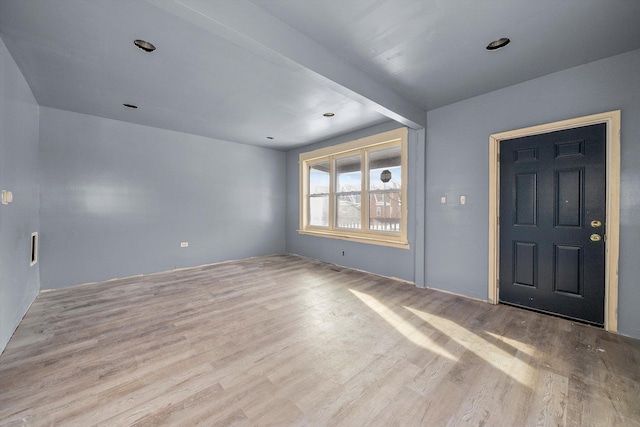 entryway featuring beamed ceiling and light hardwood / wood-style flooring