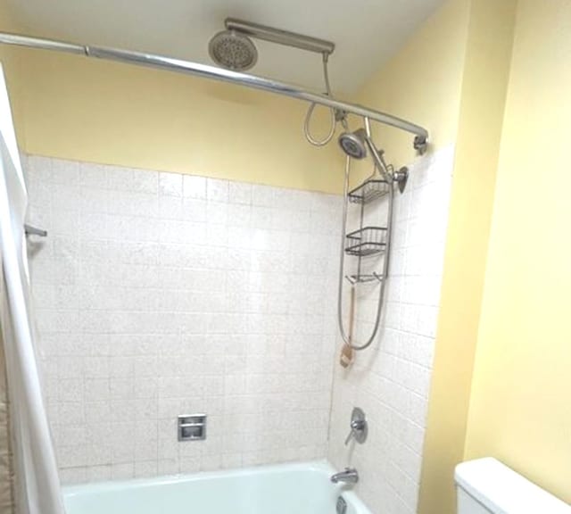 bathroom featuring shower / bath combination with curtain and toilet