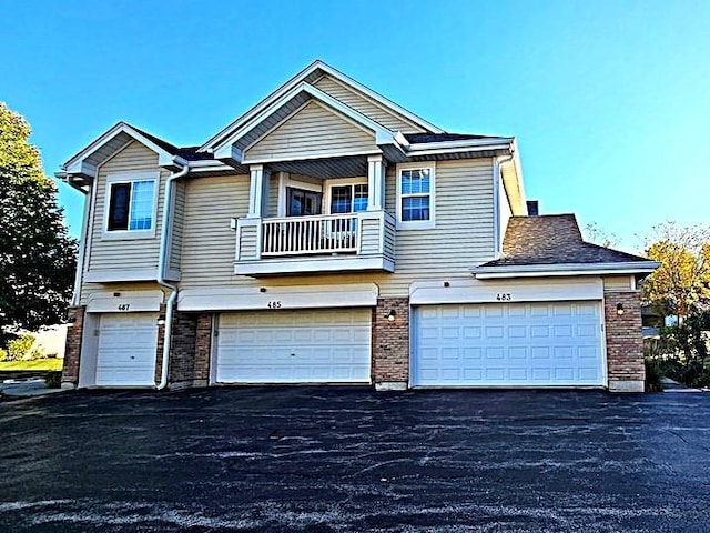 view of front facade featuring a garage and a balcony