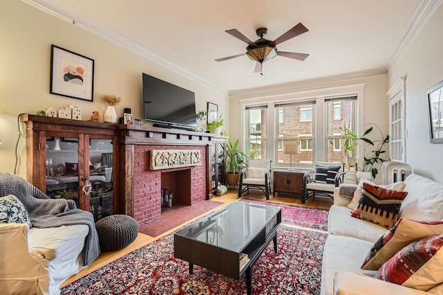 living room with ceiling fan, ornamental molding, wood-type flooring, and a brick fireplace