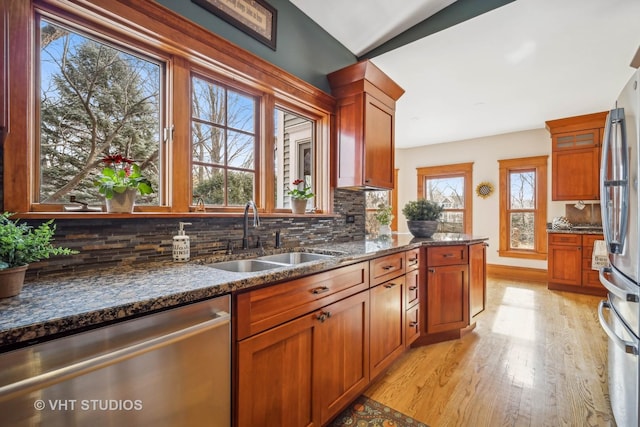 kitchen with dark stone countertops, sink, backsplash, and stainless steel appliances