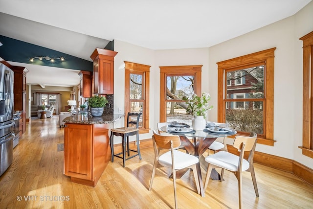 dining space featuring lofted ceiling and light hardwood / wood-style floors