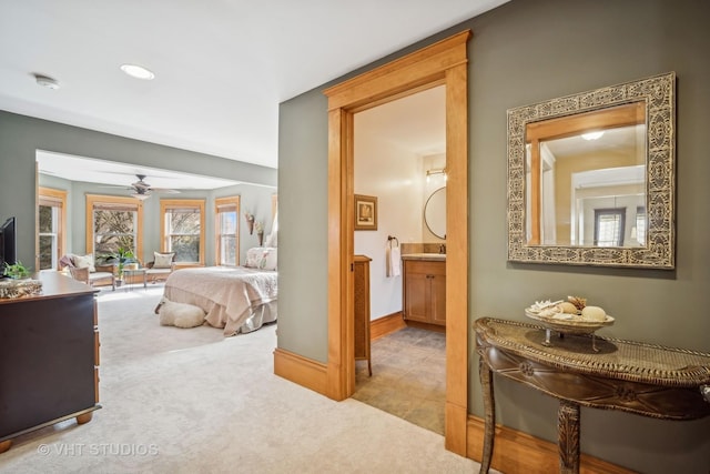 bedroom featuring light colored carpet and ensuite bath