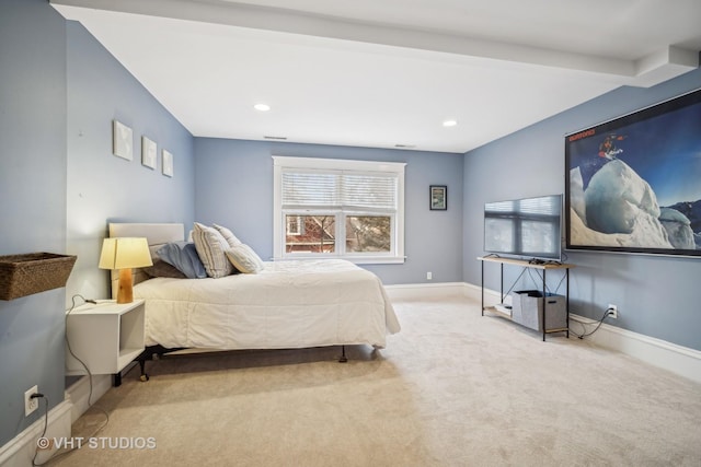 bedroom featuring light colored carpet and beam ceiling