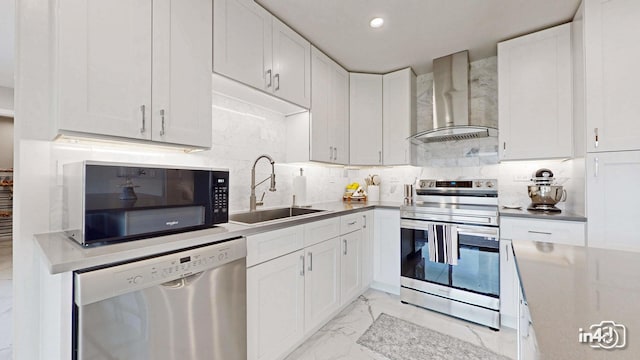 kitchen featuring stainless steel appliances, sink, white cabinets, and wall chimney exhaust hood