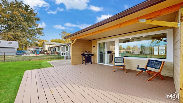 wooden deck with area for grilling and a yard