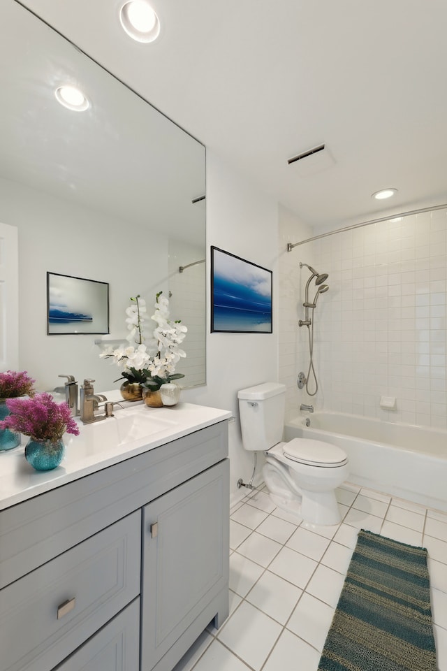 full bathroom with tiled shower / bath, vanity, tile patterned floors, and toilet