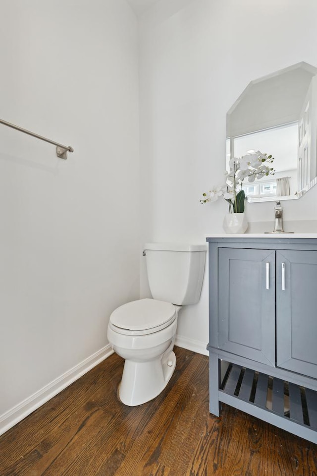 bathroom with hardwood / wood-style flooring, vanity, and toilet