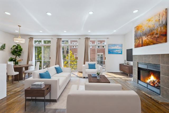 living room featuring a tile fireplace and light wood-type flooring